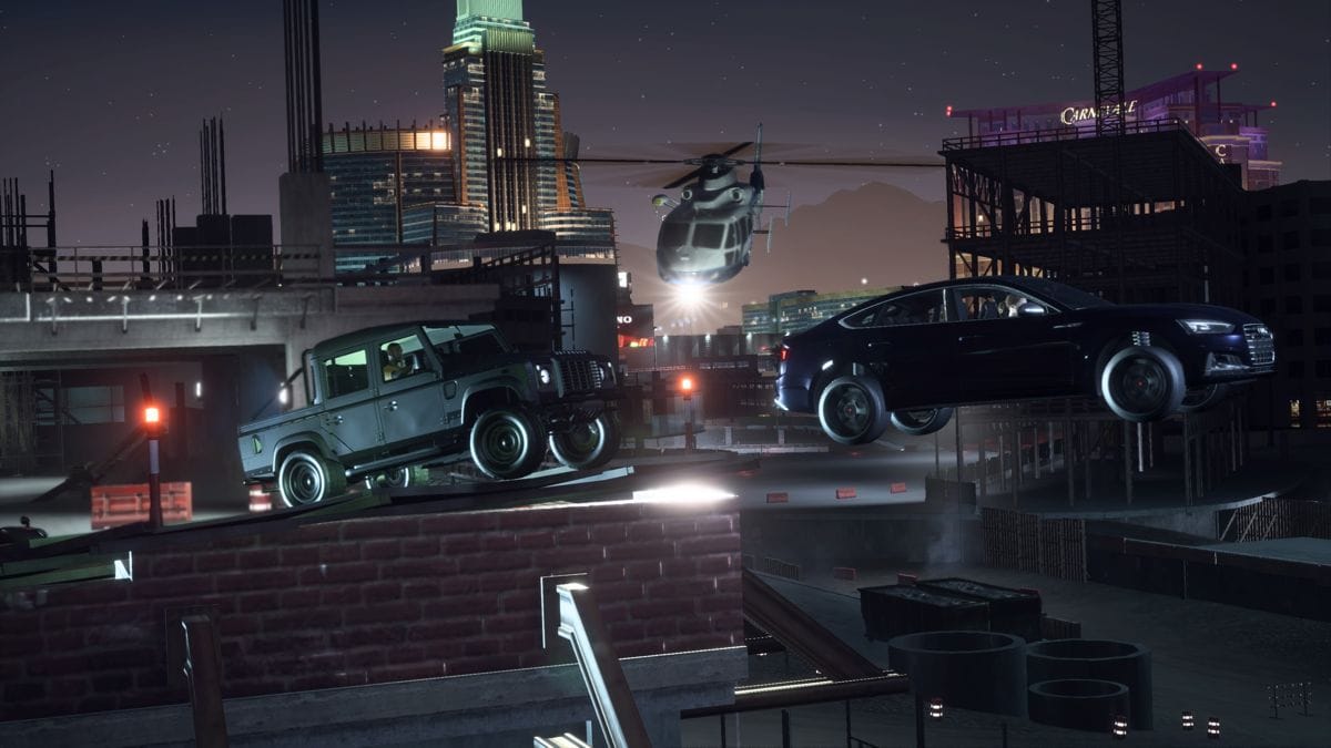 An Audi S7 and a Range Rover truck jump out of a unfinished building while being chased by a police helicopter.