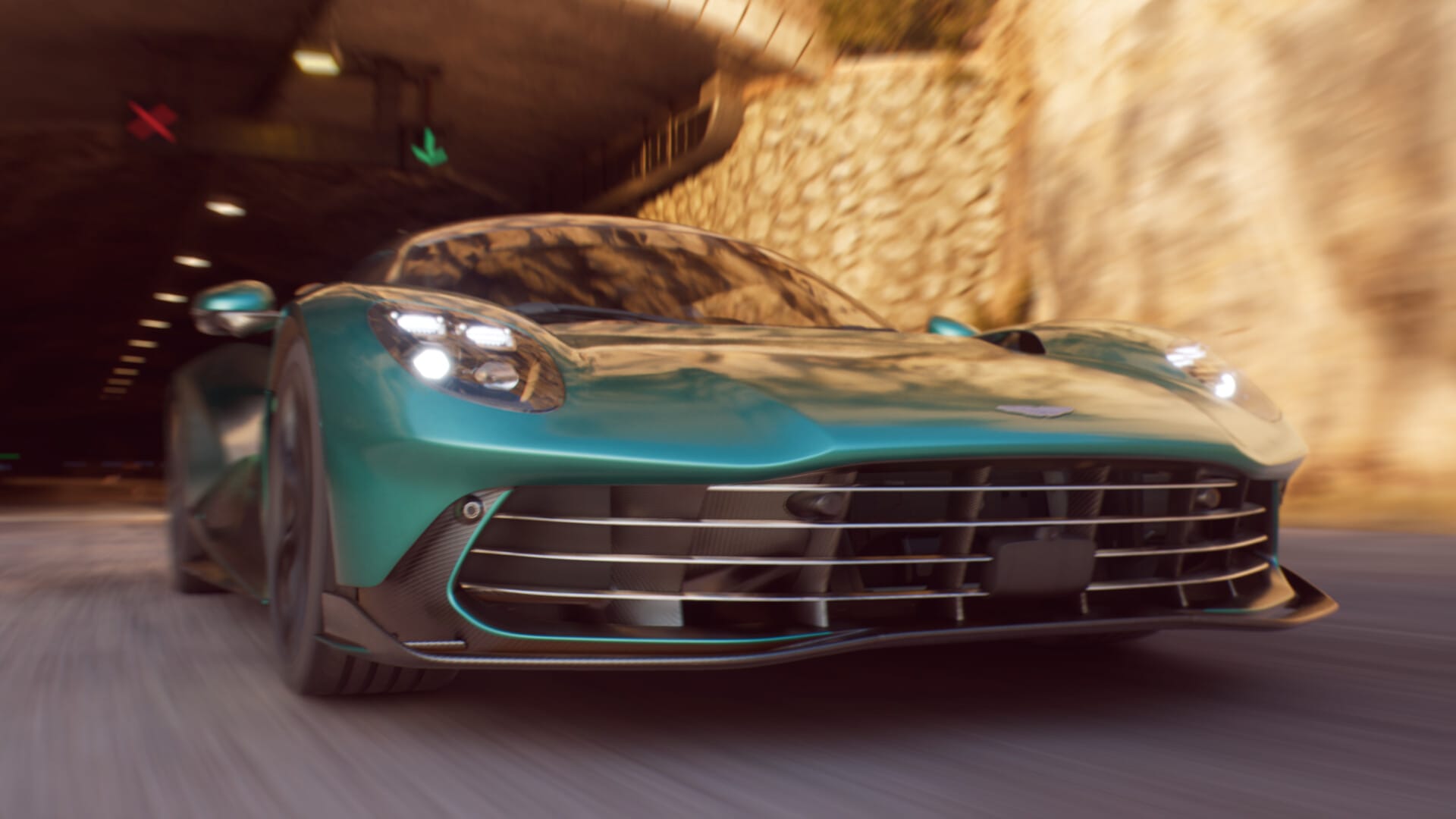A Aston Martin Valhalla driving out of a tunnel at a high rate of speed.