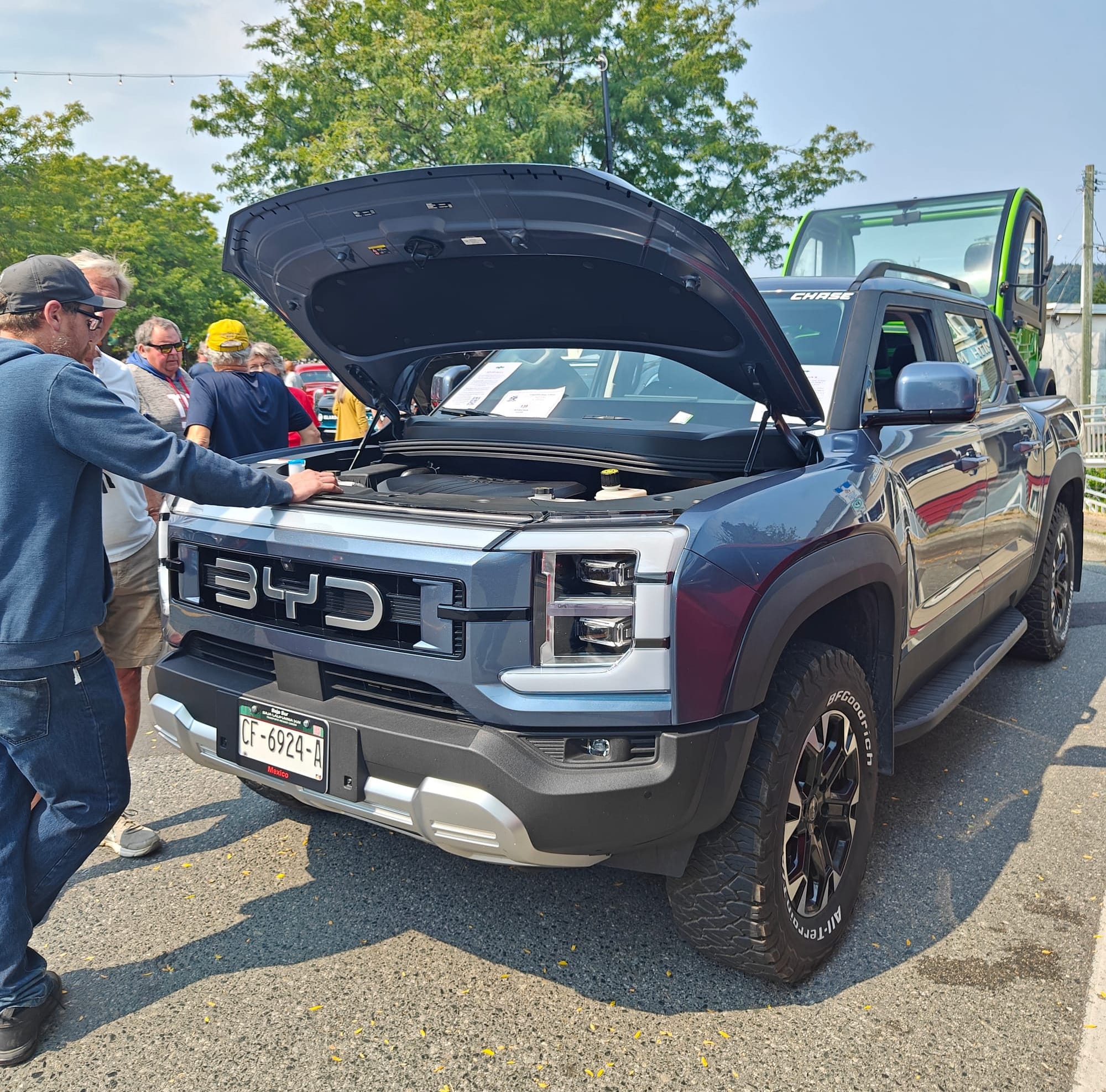 The BYD Shark 6 with it's owner talking with some car show patrons about the truck.