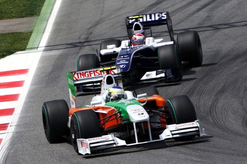 The white, with green and orange Force India VJM02 of Giancarlo Fisichella is being chased by the blue and white Williams of Kazuki Nakajima.