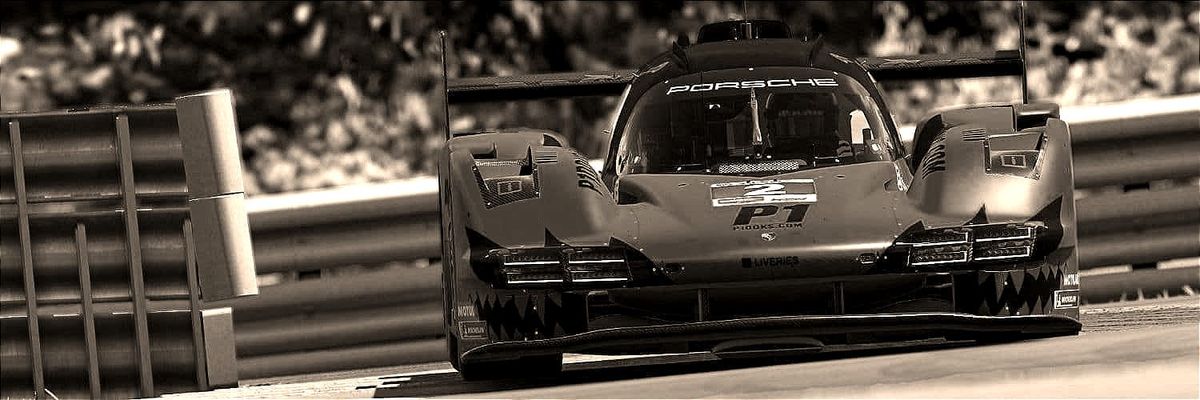 A Porsche 963 Le Mans Prototype race car entering the chicane at Watkens Glen International, with the armco barrier at the start of that corner sequence to it's inside.