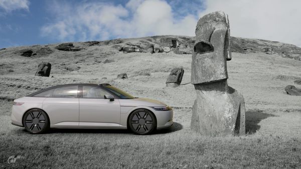 A Sony Honda Afeela 1 sedan parked beside an Maoi on Easter Island.