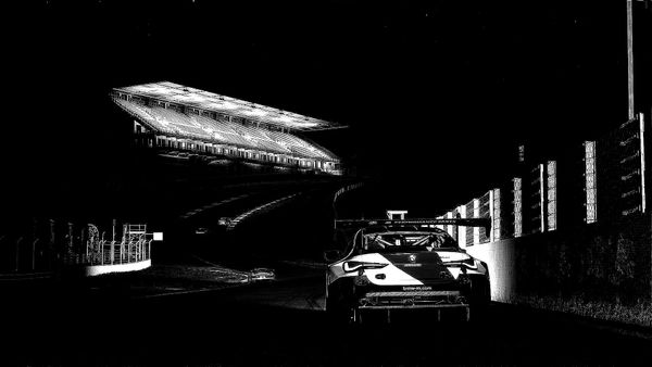 A black and white image of a BMW M4 GT3 about to go up the Eau Rouge-Radillon section at Spa-Francorchamps.
