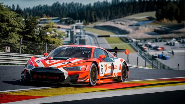 A red with white and black Audi R8 LMS goes up Eau Rouge-Radillon in Rennsport.
