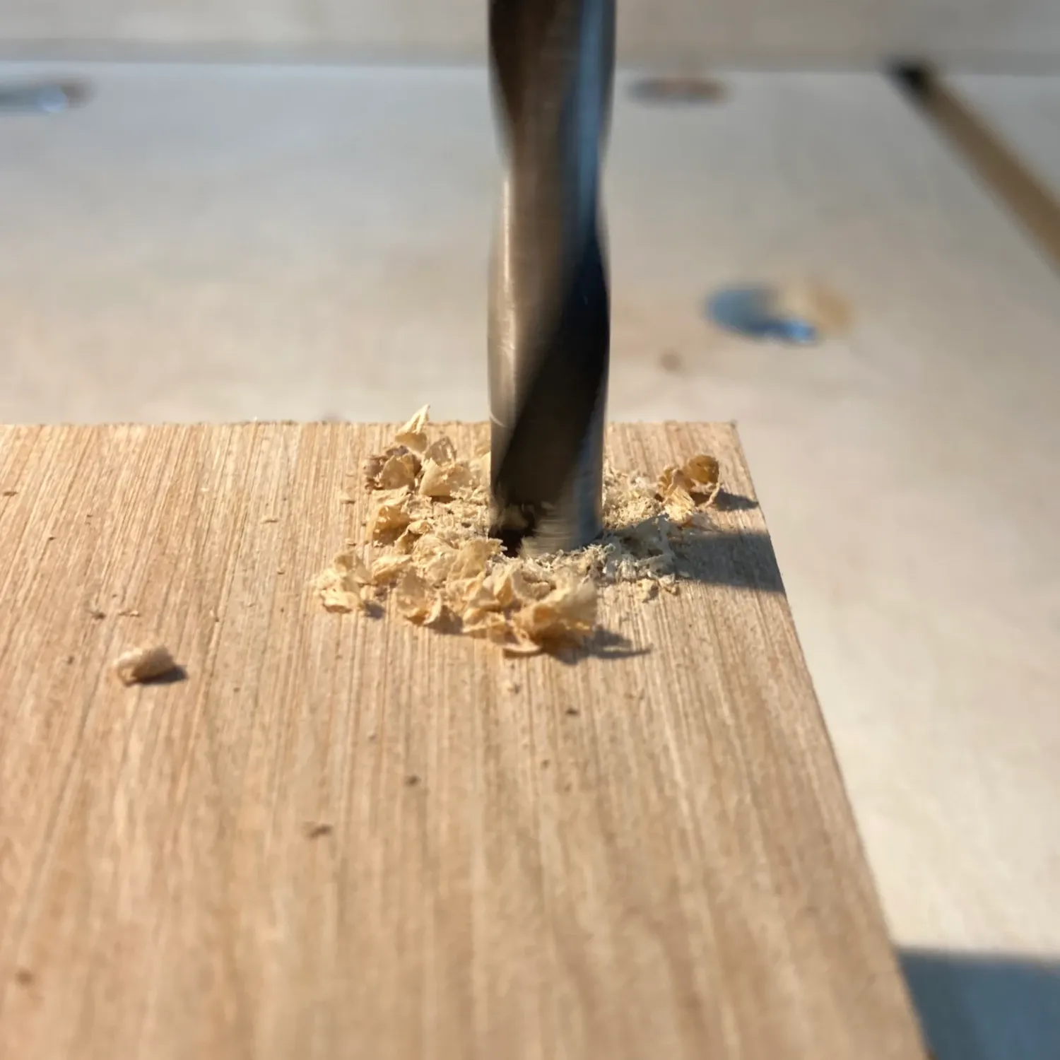 An image showing a drill plunging into a piece of wood.