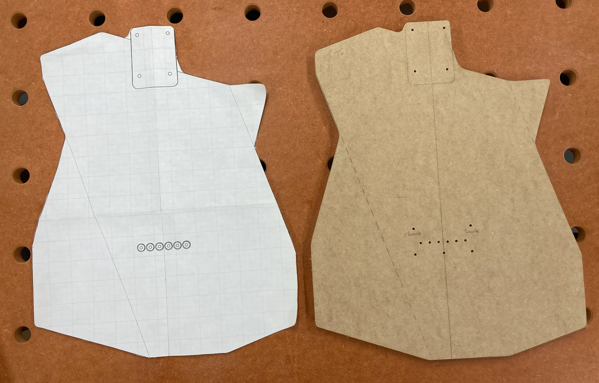 A photo showing my drawing next to the finished guitar template.