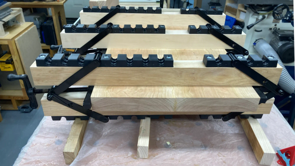 Image showing a cherry guitar body blank clamped with three 4-way Equipressure clamps.