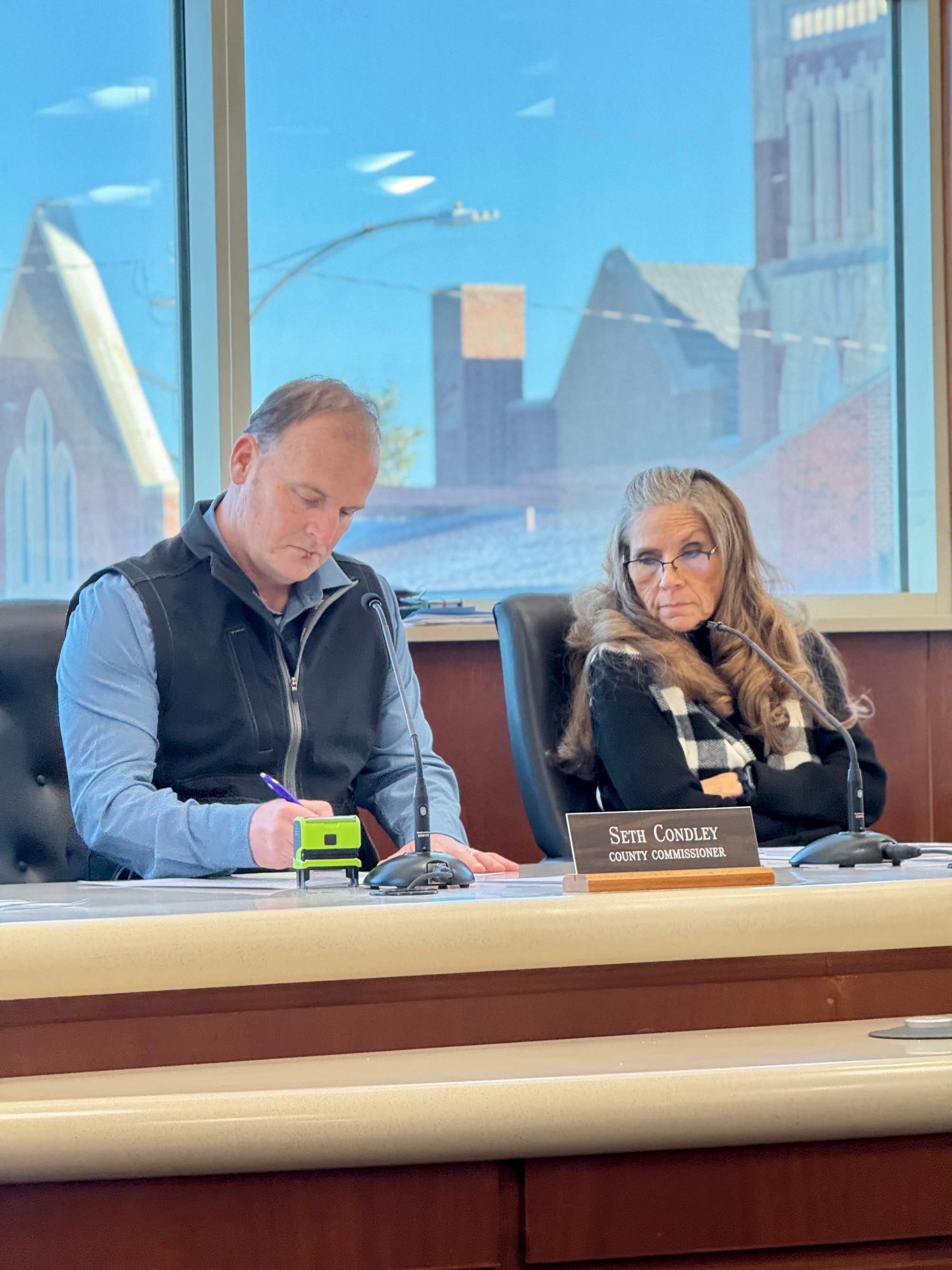 Commissioners Condley and Markum looking over meeting papers.