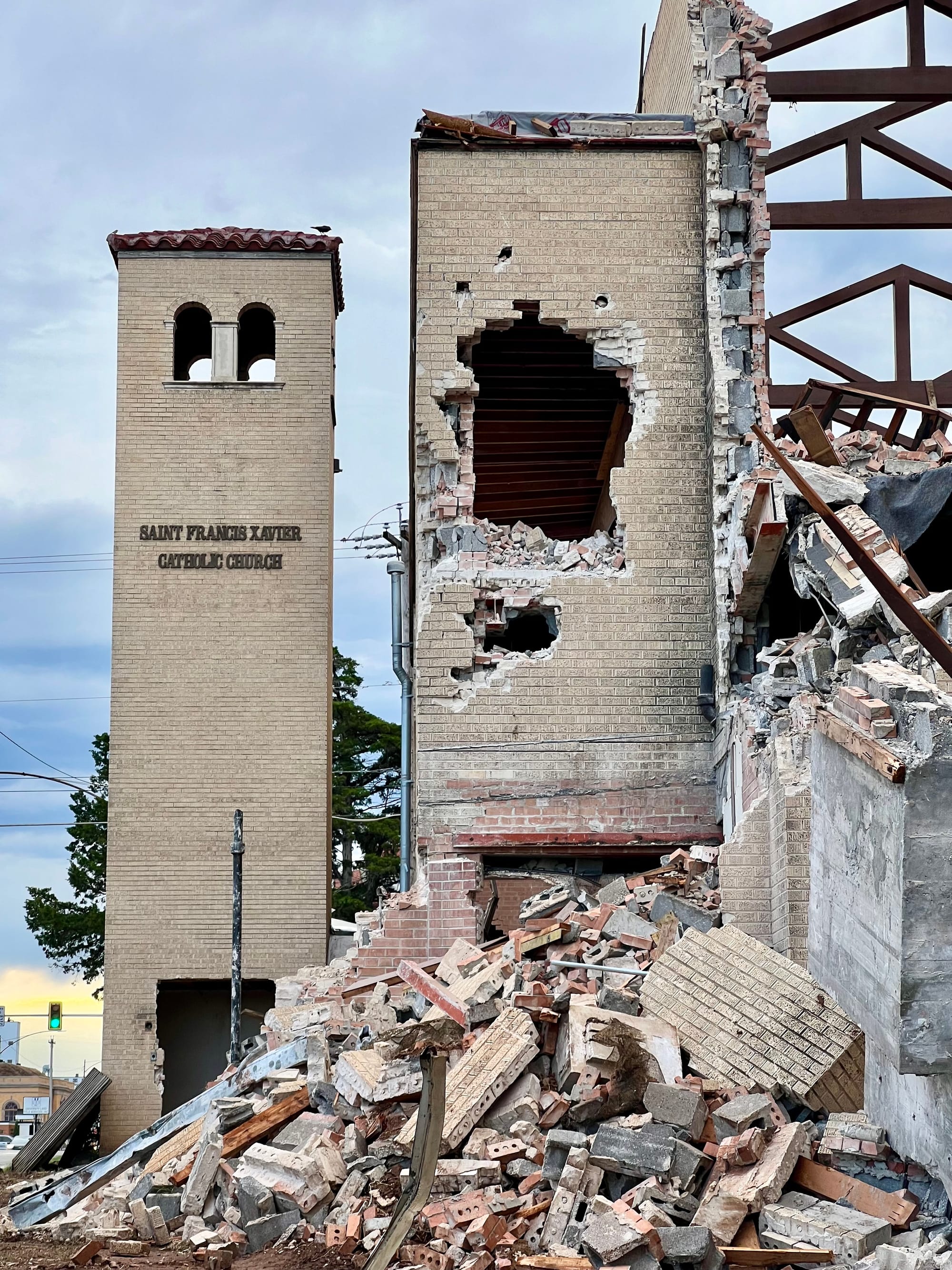 Demolition, bell tower remaining with sign Saint Francis Xavier Catholic Church