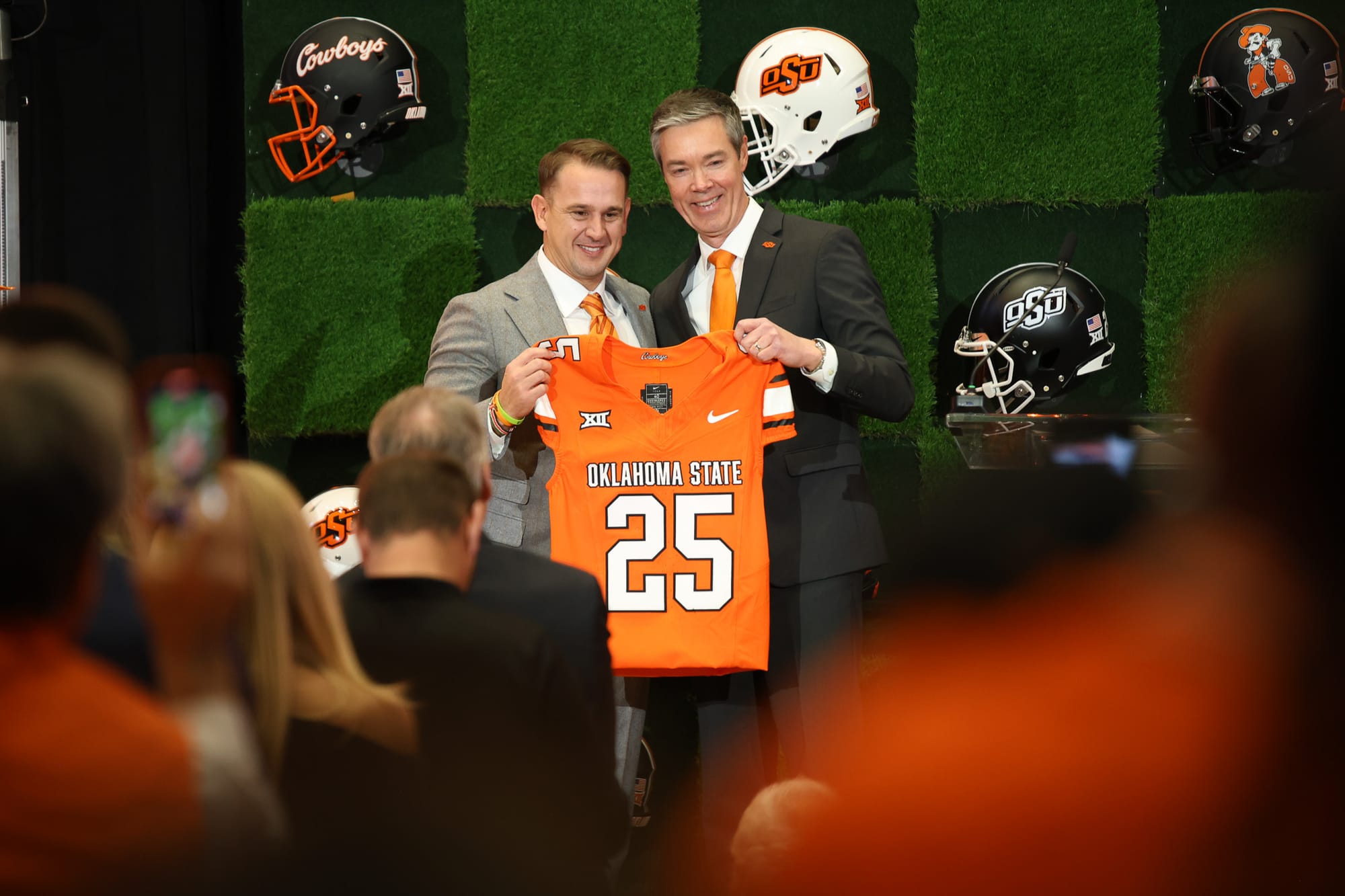 Eric Morris and Chad Weiberg hold Oklahoma State jersey at head coach introductory press conference