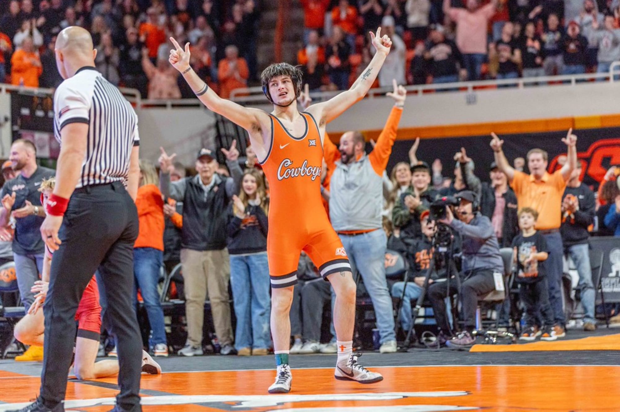 Oklahoma State wrestler Jax Forrest in orange singlet celebrates with arms raised after pinning Oklahoma opponent on Jan. 11, 2026, at Gallagher-Iba Arena in Stillwater, Oklahoma.