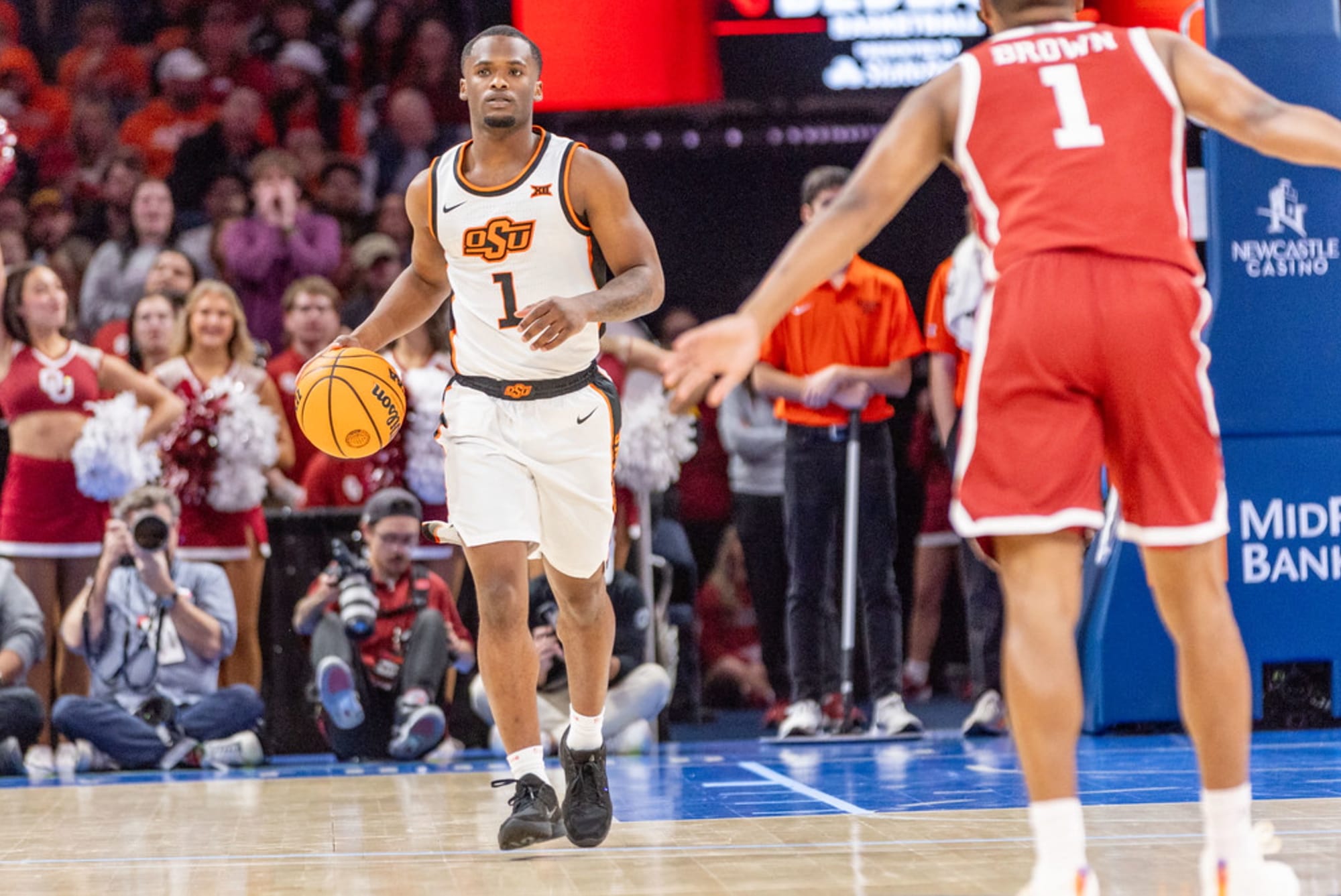 Oklahoma State point guard Kanye Clary (1) dribbles the ball up the court in his black and orange OSU jersey against Oklahoma at Paycom Arena in Oklahoma City.