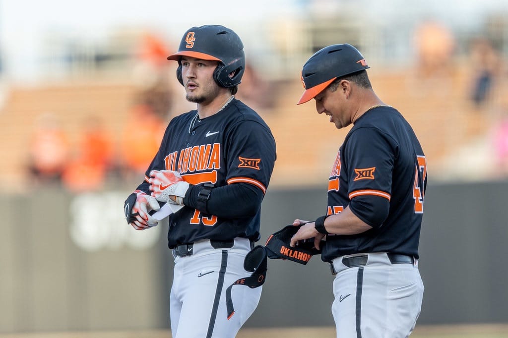 Oklahoma State's Kollin Ritchie (13) talks with coach at first base during game vs North Dakota State at O'Brate Stadium, March 18, 2025.