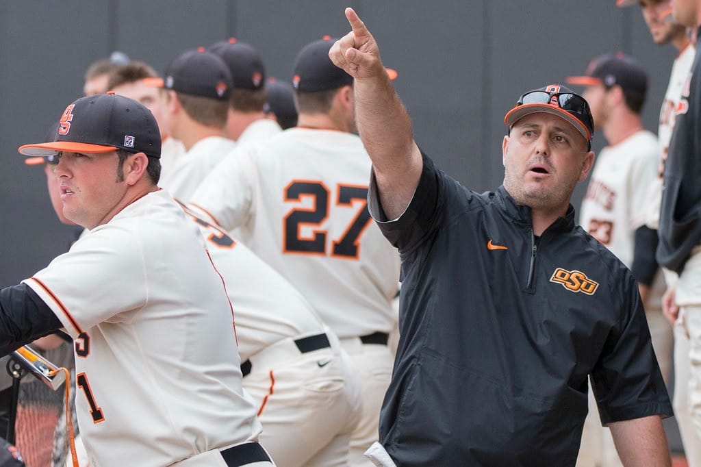 OSU graduate assistant Roland Fanning, left, and head coach Josh Holliday direct players from the dugout during a game against Kansas at Allie P. Reynolds Stadium in Stillwater on April 19, 2014.