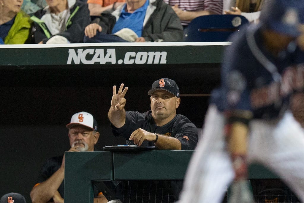 OSU head coach Josh Holliday signals from the dugout during the 2016 College World Series against Arizona at TD Ameritrade Park in Omaha, Neb., on June 20, 2016.