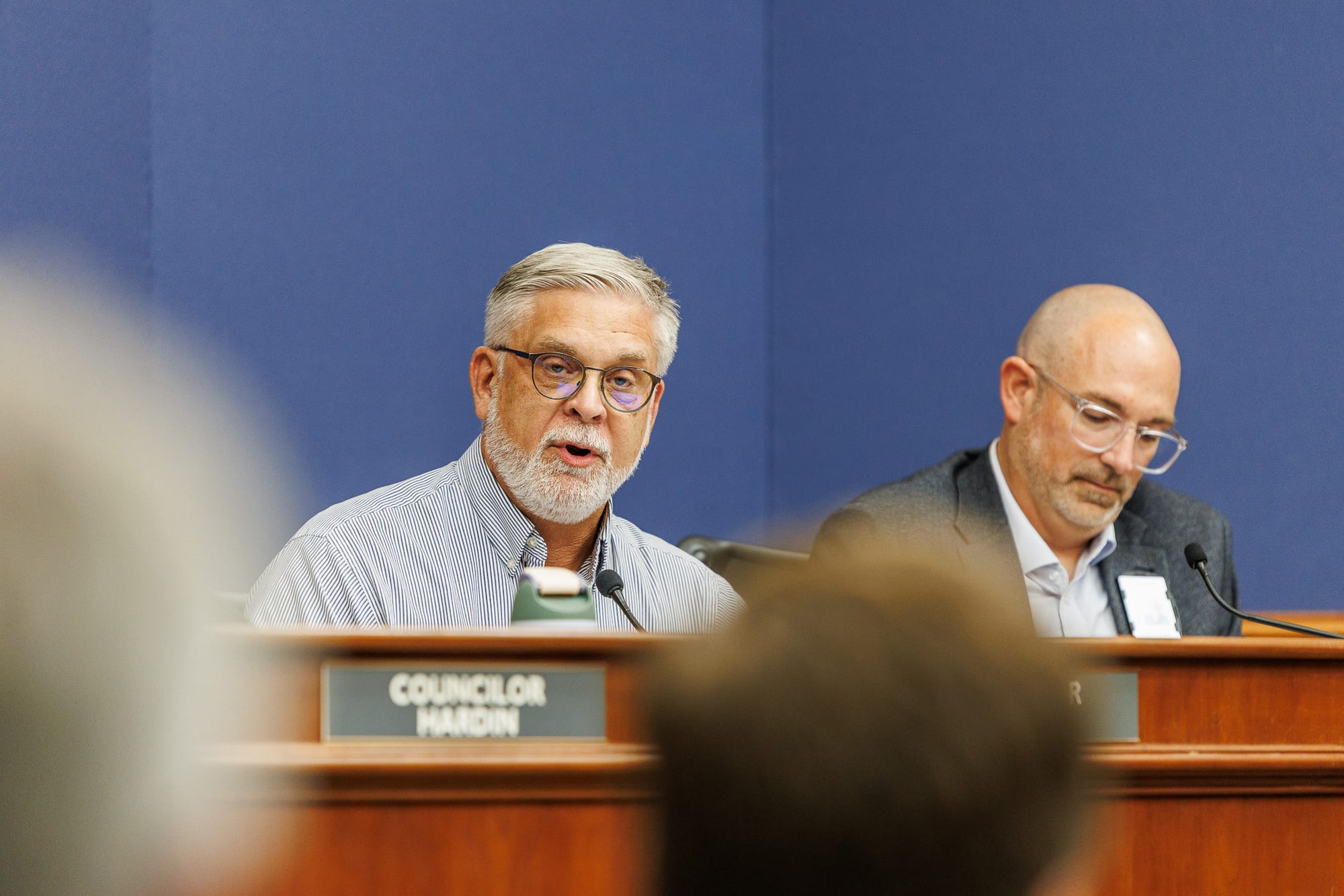 Stillwater City Councilor Kevin Clark speaks at the council dais during the May 18, 2026 meeting, with another council member visible in the background.