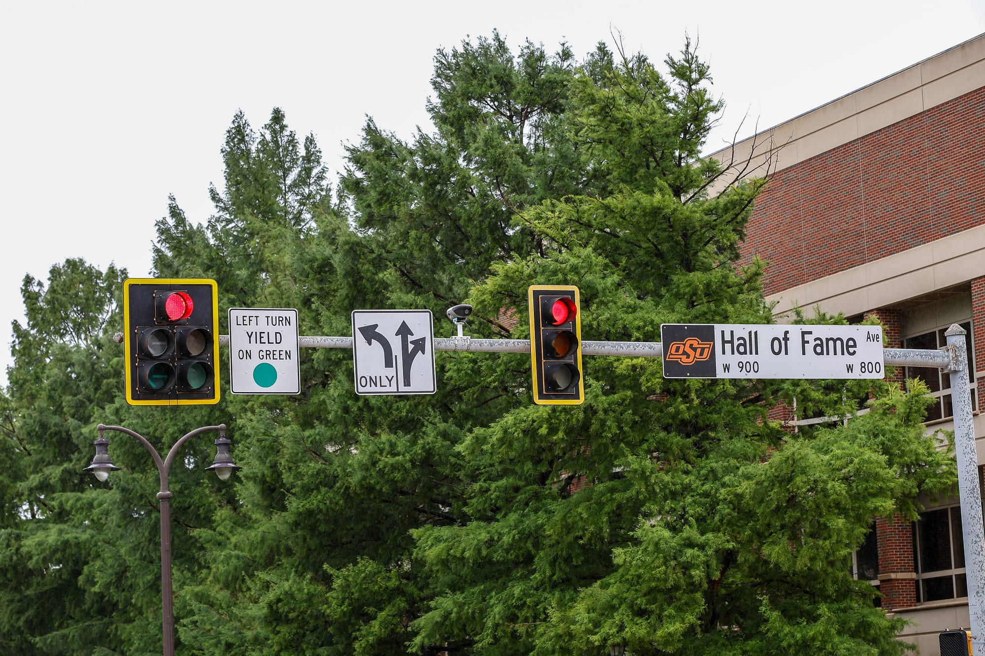 Traffic signals and street signs at Duck Street and Hall of Fame Avenue near the Oklahoma State University campus in Stillwater, May 2026.