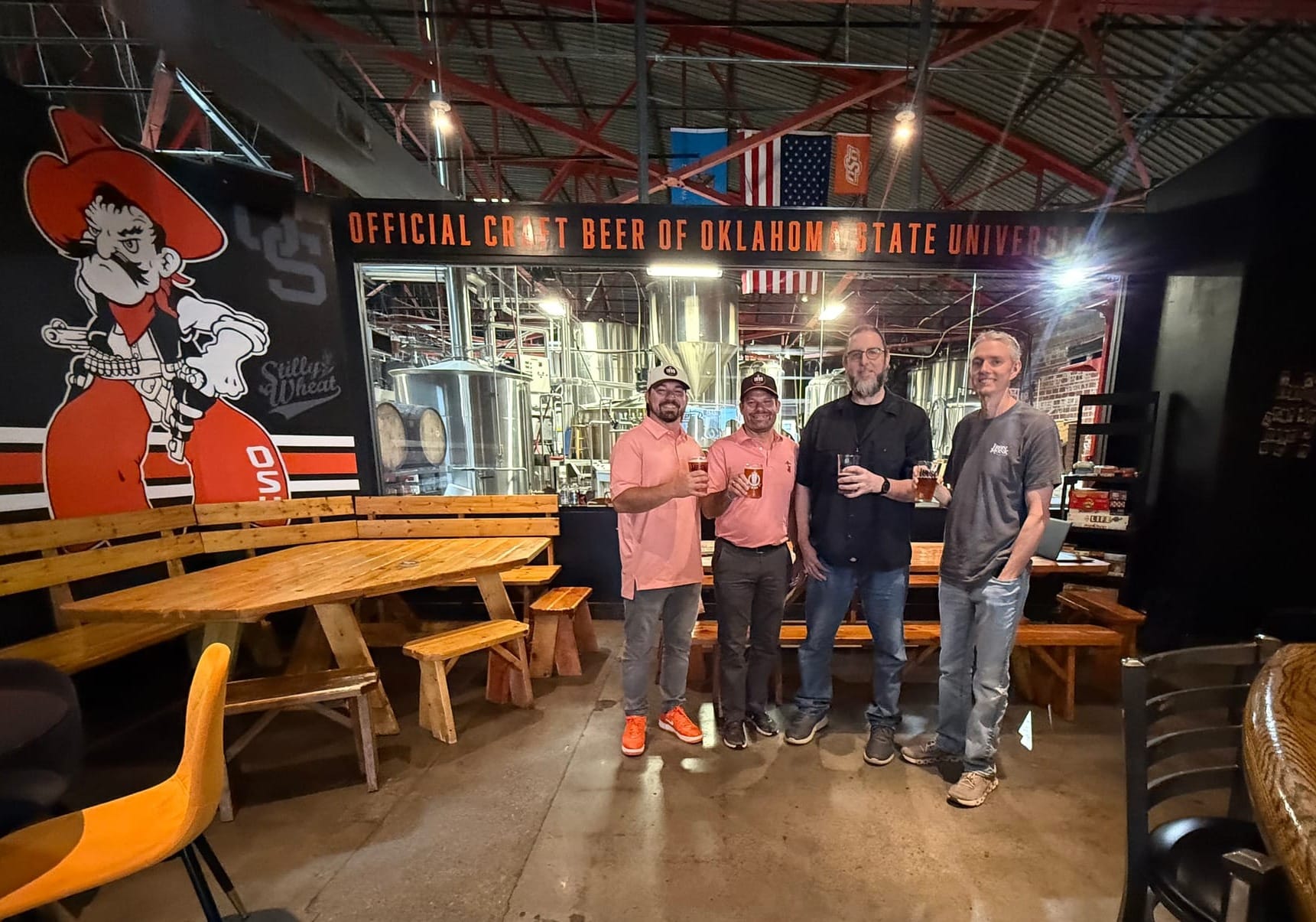 From left, Trenton Inselman, Brady Sidwell, Dave Monks and Jerod Millirons hold beer glasses inside Iron Monk Brewing Company's taproom.