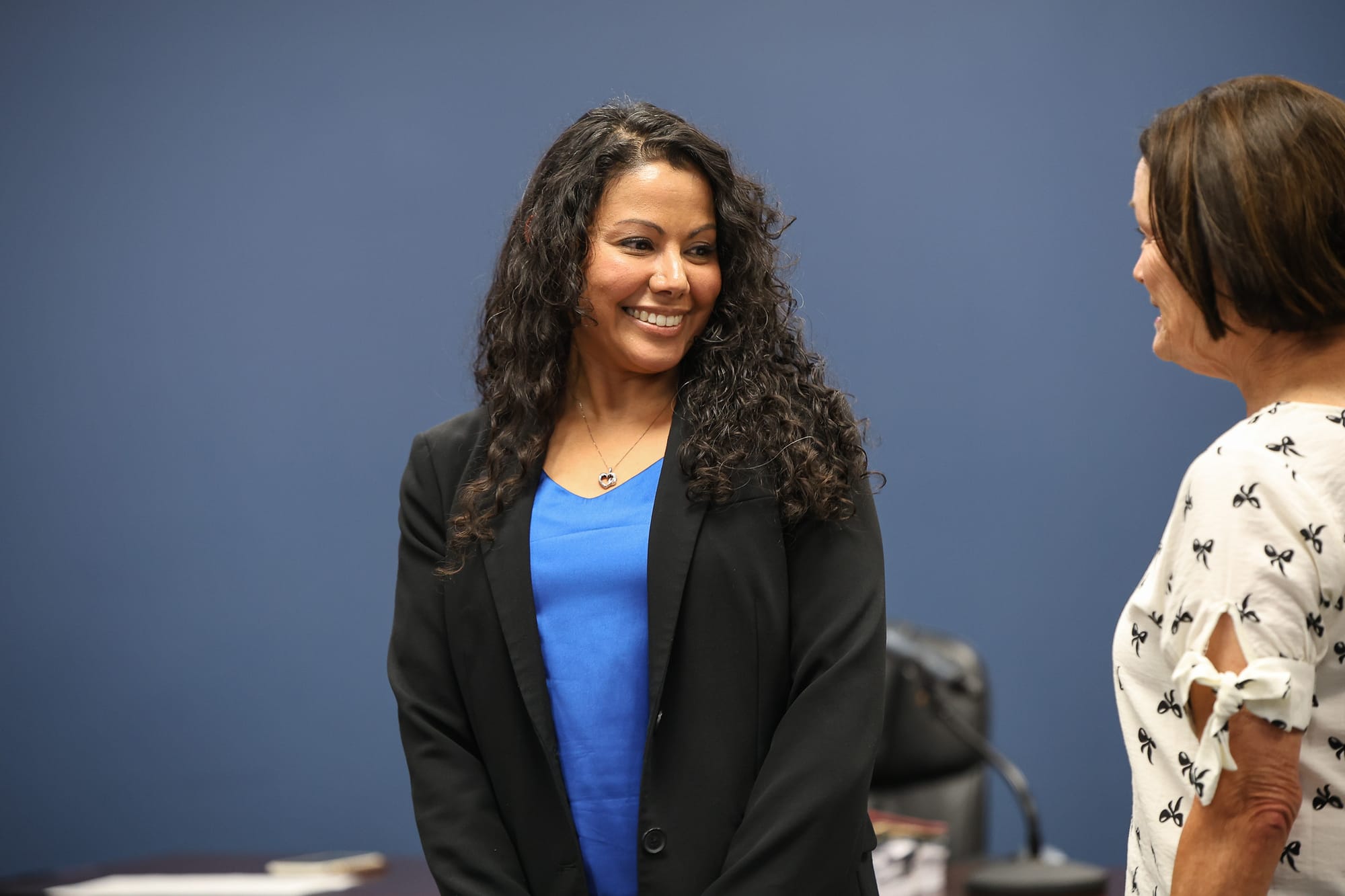Kiah Butcher smiles while speaking with Board President Gay Washington after being sworn in to the Stillwater Board of Education Tuesday, July 14, 2026.