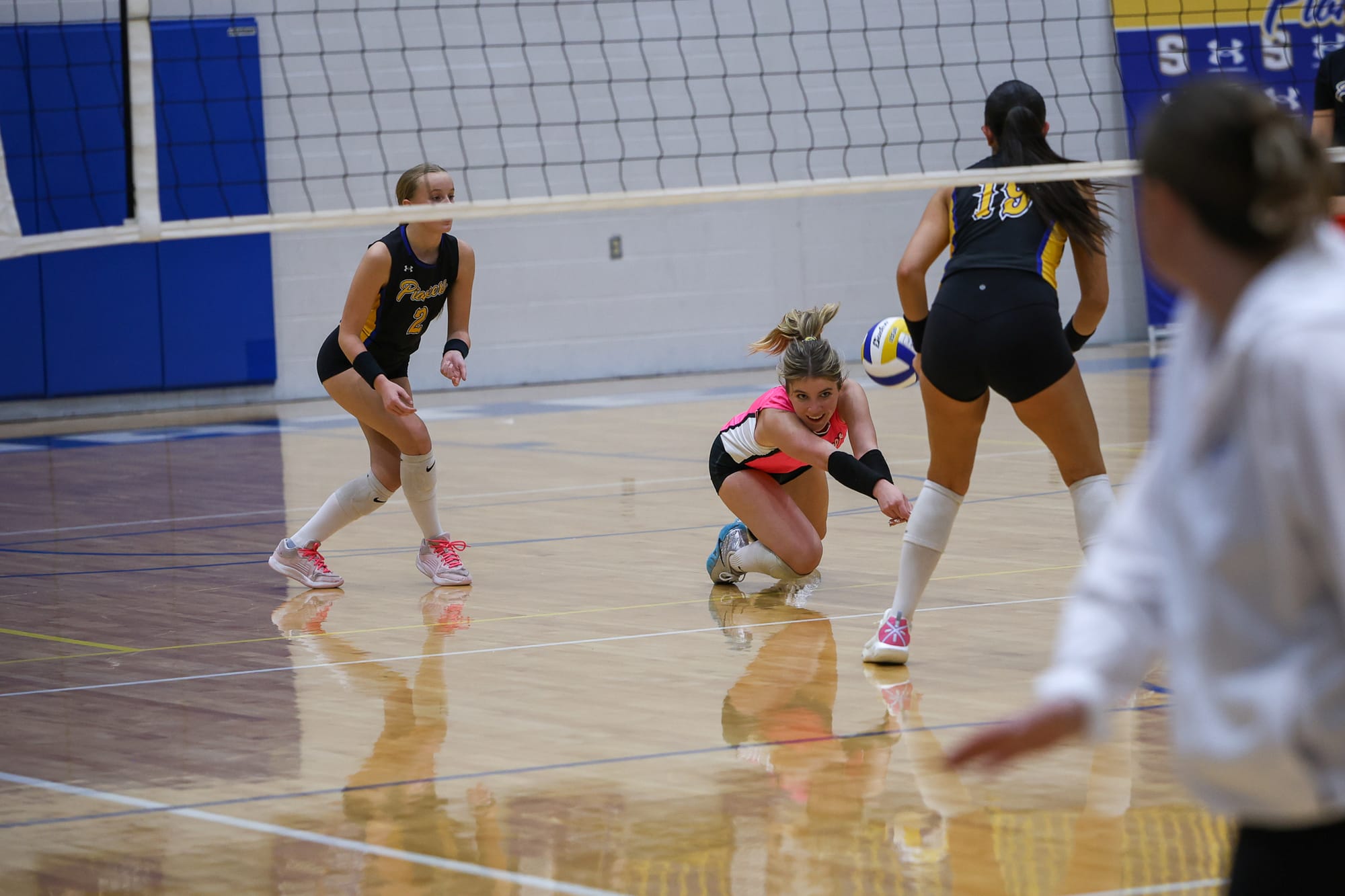Stillwater libero Prentiss Martin dives to dig a ball as teammates Kael Valdois and Sadie Moore look on against Sapulpa on Oct. 1, 2026, at Pioneer Fieldhouse.