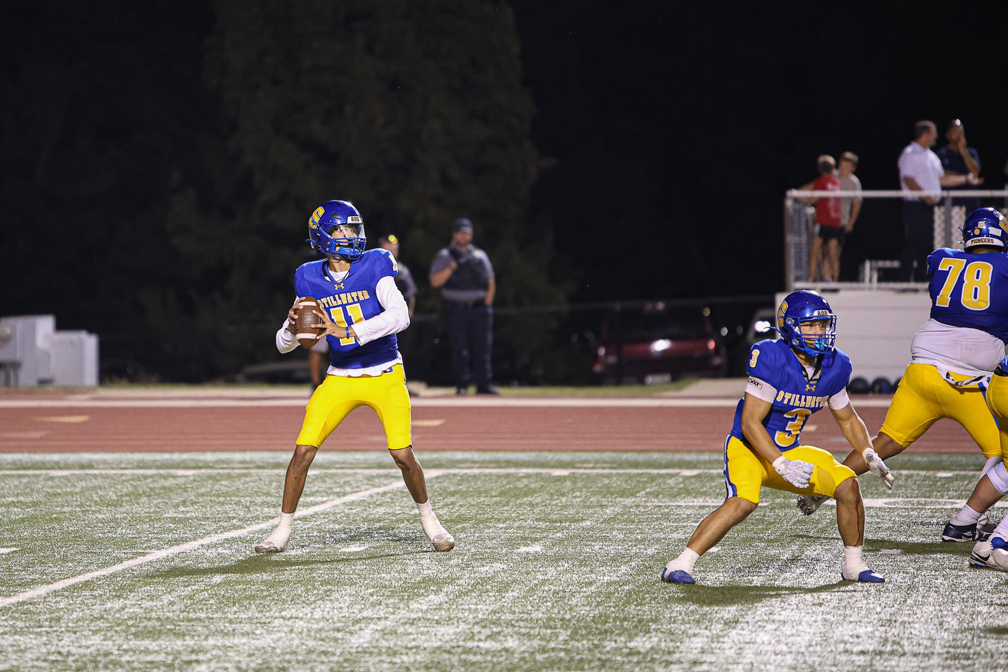Stillwater quarterback Satank Taptto (11) sets to pass in the pocket as running back Jaedan Adams (3) and lineman Daniel Hornbeck (78) block against Ponca City at Pioneer Stadium.