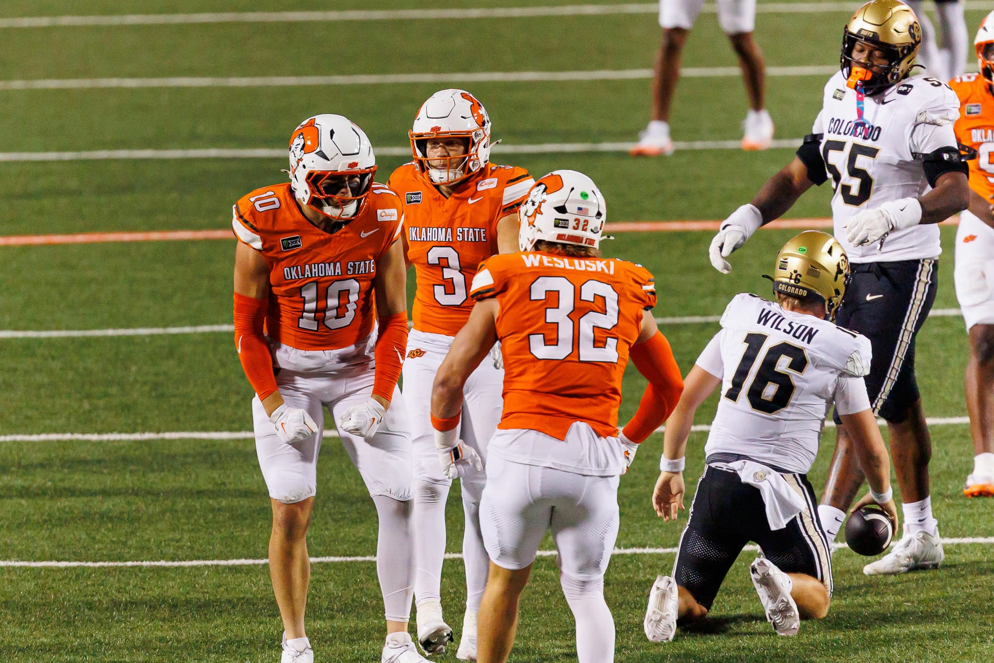 OSU defenders James Williams, Tate Romney, and Ethan Wesloski celebrate as Colorado quarterback Isaac Wilson kneels on the field on Oct. 24, 2026, at Boone Pickens Stadium.