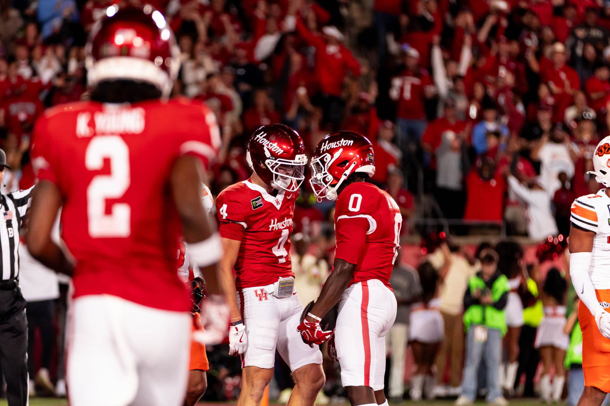 Houston receivers Trent Walker (4) and Amare Thomas (0) celebrate a touchdown as Koby Young (2) approaches in a 35-32 win over Oklahoma State on Oct. 17, 2026, at TDECU Stadium in Houston.