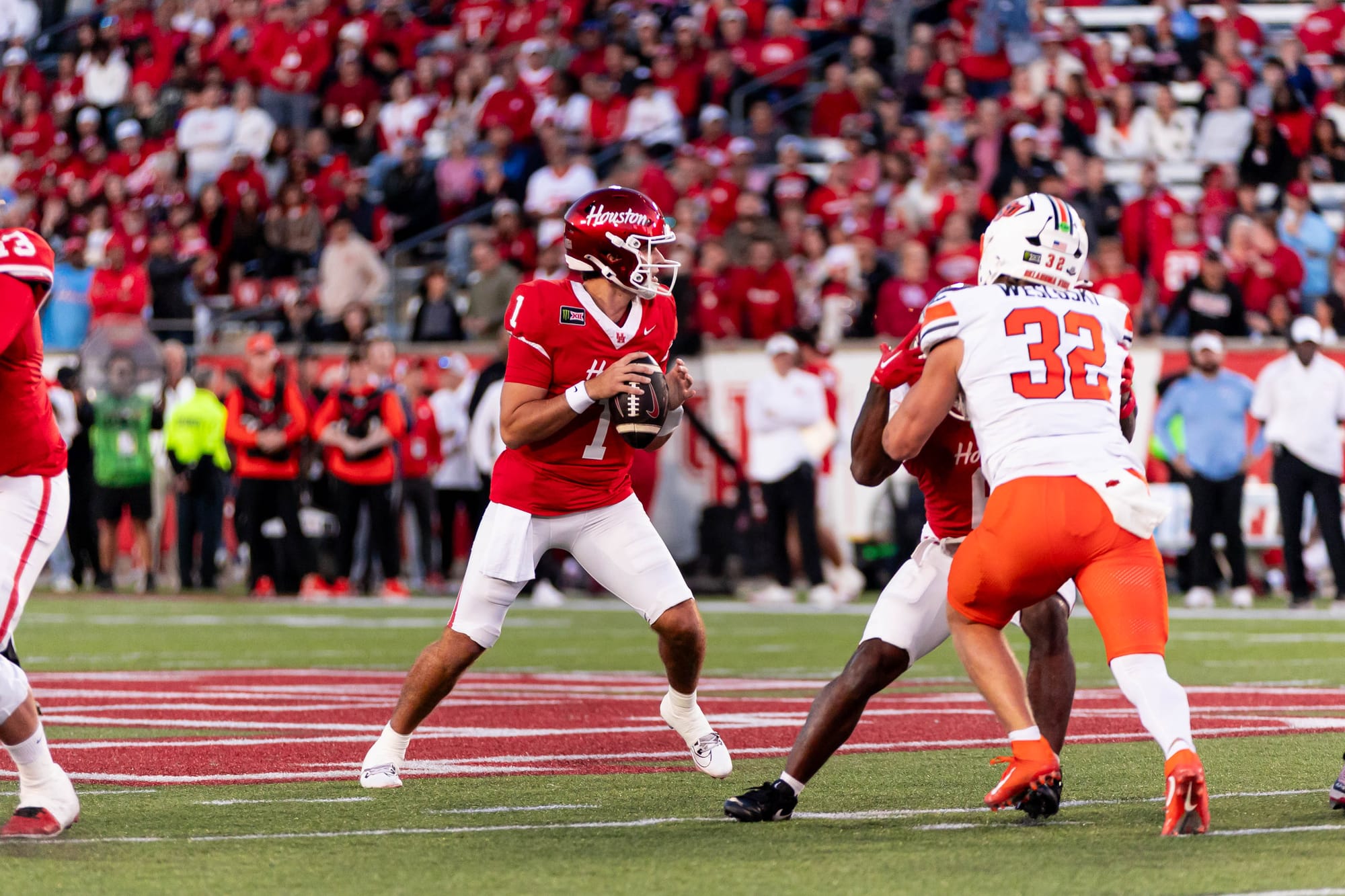 Houston quarterback Conner Weigman (1) drops back to pass as OSU linebacker Ethan Wesloski (32) rushes on Oct. 17, 2026, at TDECU Stadium in Houston.