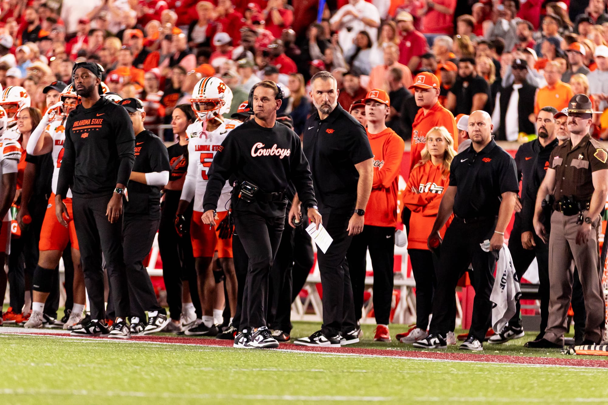 OSU head coach Eric Morris, wearing a headset and a black Cowboys sweatshirt, walks the sideline during a 35-32 loss to Houston on Oct. 17, 2026, at TDECU Stadium in Houston.