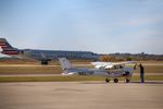 An American Eagle regional jet taxis behind a general aviation plane and two people preparing it on the tarmac at Stillwater Regional Airport on Nov. 7, 2025.