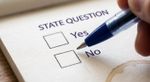 AI-generated illustration of a hand holding a blue pen over a paper ballot reading "State Question," with unmarked boxes next to "Yes" and "No."