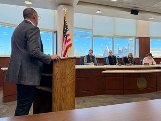 In the County board room Brady Moore speaks with Commissioners Cavett, Condley, Markum and Clerk Glenna Craig