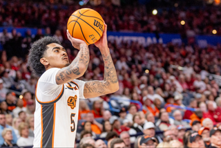 Oklahoma State guard Vyctorious Miller shoots a free throw in white Cowboys uniform with focused expression. 