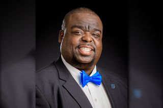 Dr. Clyde Wilson wearing dark suit and blue bow tie in professional portrait