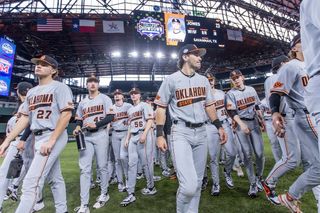 OSU baseball players in gray uniforms take the field at Globe Life Field during the Shriners Children's College Showdown. Cowboys open 2026 season at same Arlington tournament.