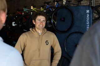 Cameron Jones at a pre-race meet-and-greet at District Bicycles in Stillwater, Oklahoma, March 12, 2026, wearing a Scott Cycling hoodie.