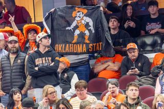 Oklahoma State fans wave a Pistol Pete flag in the stands at Rocket Mortgage Fieldhouse during the 2026 NCAA Wrestling Championships in Cleveland.