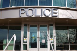 The front entrance of the Stillwater Police Department building at 723 S. Lewis St., with a large "Police" sign above the glass doors.
