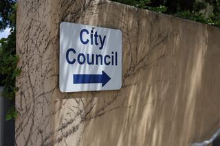 A wayfinding sign with an arrow points visitors toward the City Council chambers at Stillwater City Hall.