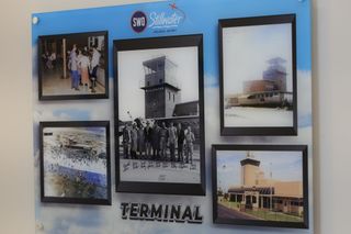 A display board inside Stillwater Regional Airport's new terminal shows historical photos of the airport, including a 1951 black-and-white photo.