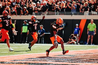 OSU safety Evan Jackson steps into the end zone holding the ball after a fumble return touchdown against UCF on Oct. 10, 2026, at Boone Pickens Stadium as teammates celebrate.