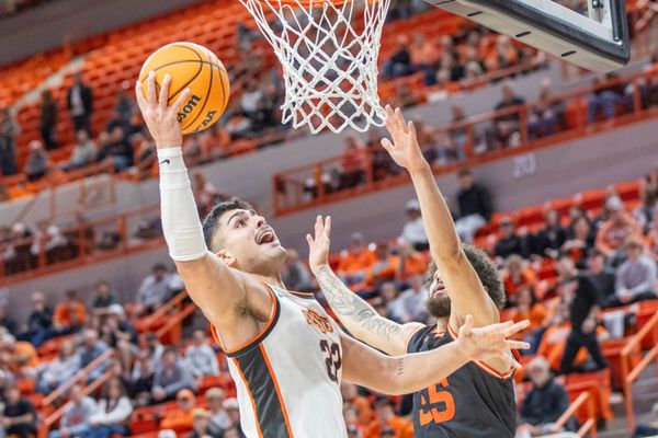 Oklahoma State center Parsa Fallah (22) drives to the basket against a Sam Houston defender during the Cowboys' game Dec. 2, 2025 at Gallagher-Iba Arena in Stillwater, Oklahoma.