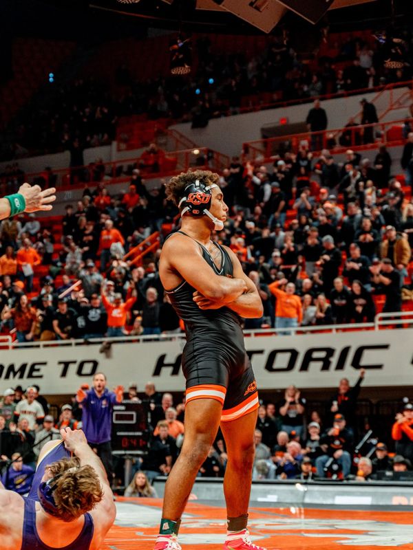 OSU wrestler Dee Lockett celebrates victory standing over opponent on mat at Gallagher-Iba Arena after securing last-second comeback win against Northern Iowa Jan. 30, 2026