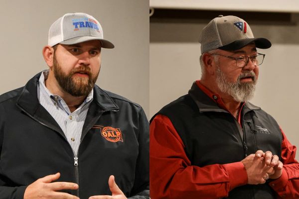 Dillon Travis, left, in black jacket and white campaign cap, and Mike Waters, right, in red shirt and gray cap, speak to voters at an OK2A meeting in Cleveland, Oklahoma.