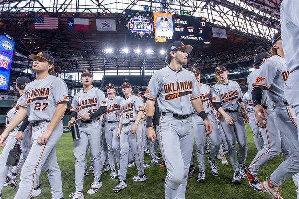 OSU baseball players in gray uniforms take the field at Globe Life Field during the Shriners Children's College Showdown. Cowboys open 2026 season at same Arlington tournament.