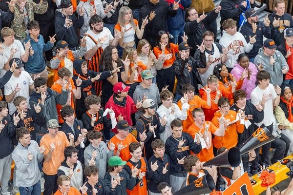 Crowd of OSU students in orange and black apparel making finger pistol gestures during basketball game against BYU at Gallagher-Iba Arena
