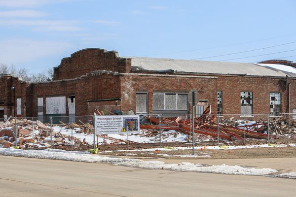 Exterior view of Washington School showing brick building with boarded windows as restoration work progresses on the historic all-Black school built in 1938 in Stillwater