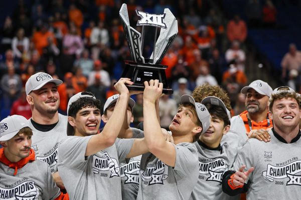 OSU wrestlers Sergio Vega and Casey Swiderski hoist the Big 12 championship trophy at the BOK Center in Tulsa on March 7, 2026.