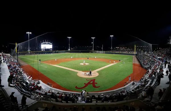 A wide view of Sewell-Thomas Stadium in Tuscaloosa, Ala., lit up for a night game. The venue hosts the 2026 Tuscaloosa NCAA Baseball Regional beginning May 29.