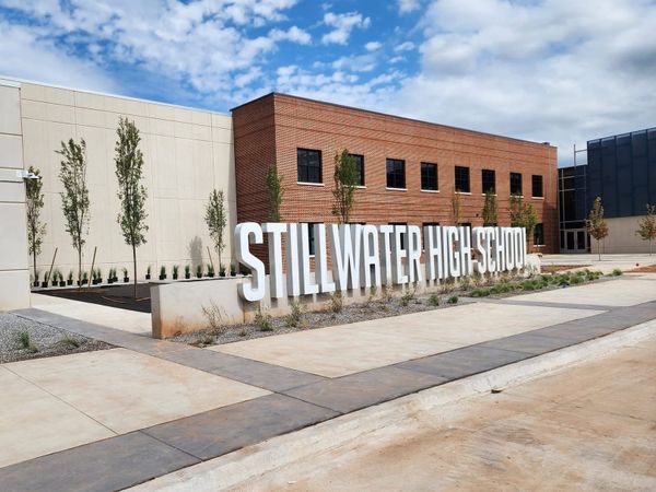 The large white letter sign reading "Stillwater High School" stands at the front entrance of the new campus still under construction.